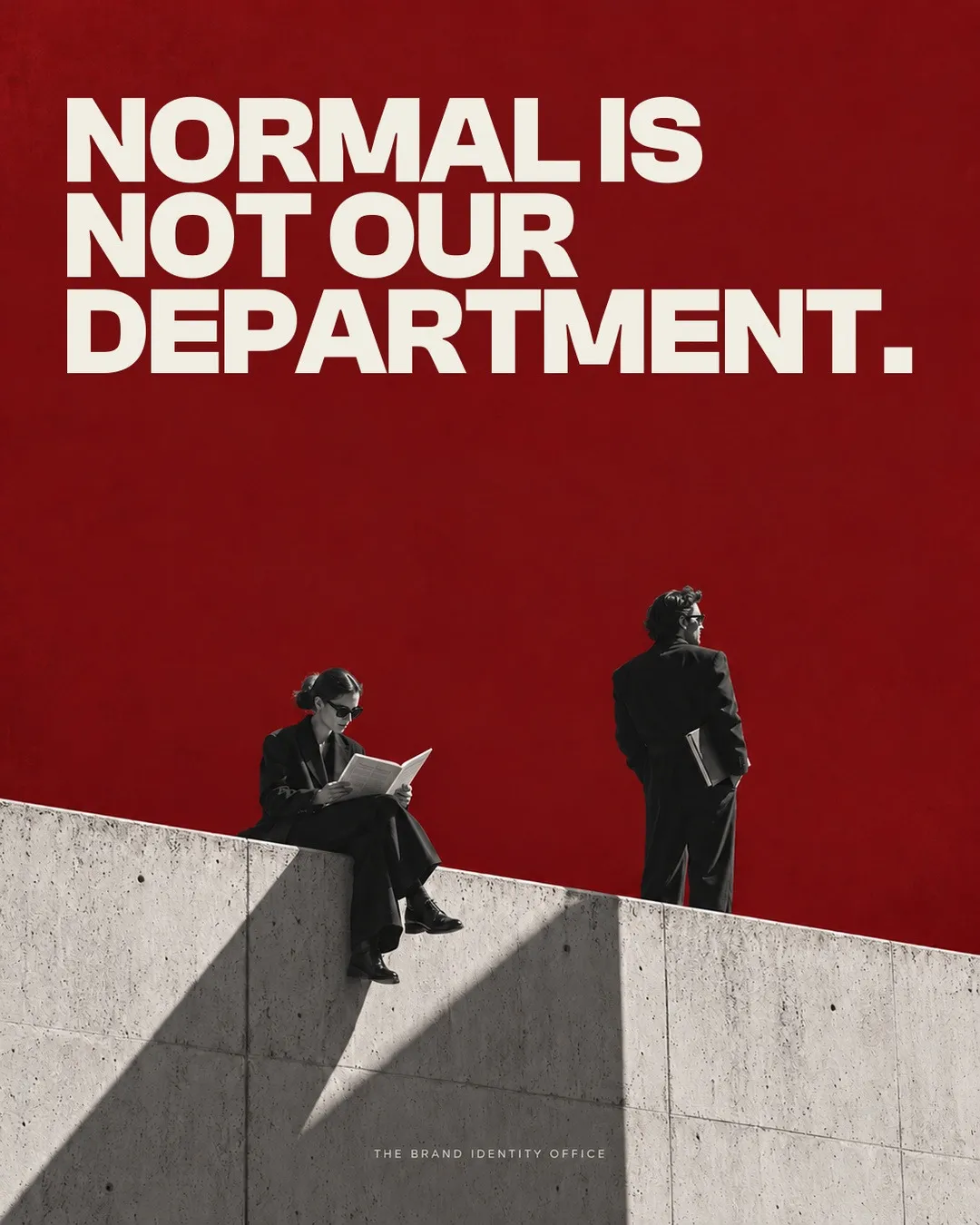 Red poster: NORMAL IS NOT OUR DEPARTMENT, two figures in black on a concrete wall.