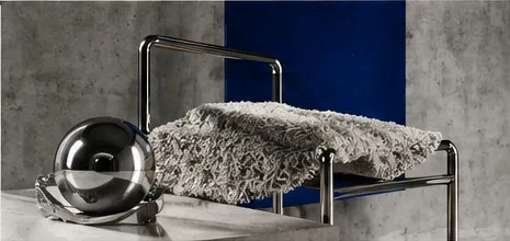 Chrome sphere and a woven textile on a tubular steel frame.